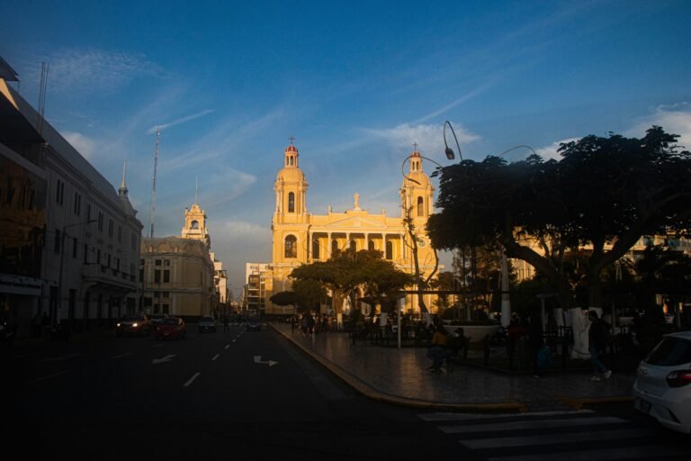 Lambayeque https://unsplash.com/es/fotos/una-calle-de-la-ciudad-bordeada-de-edificios-altos-bajo-un-cielo-azul-2k4X2lQKU_g